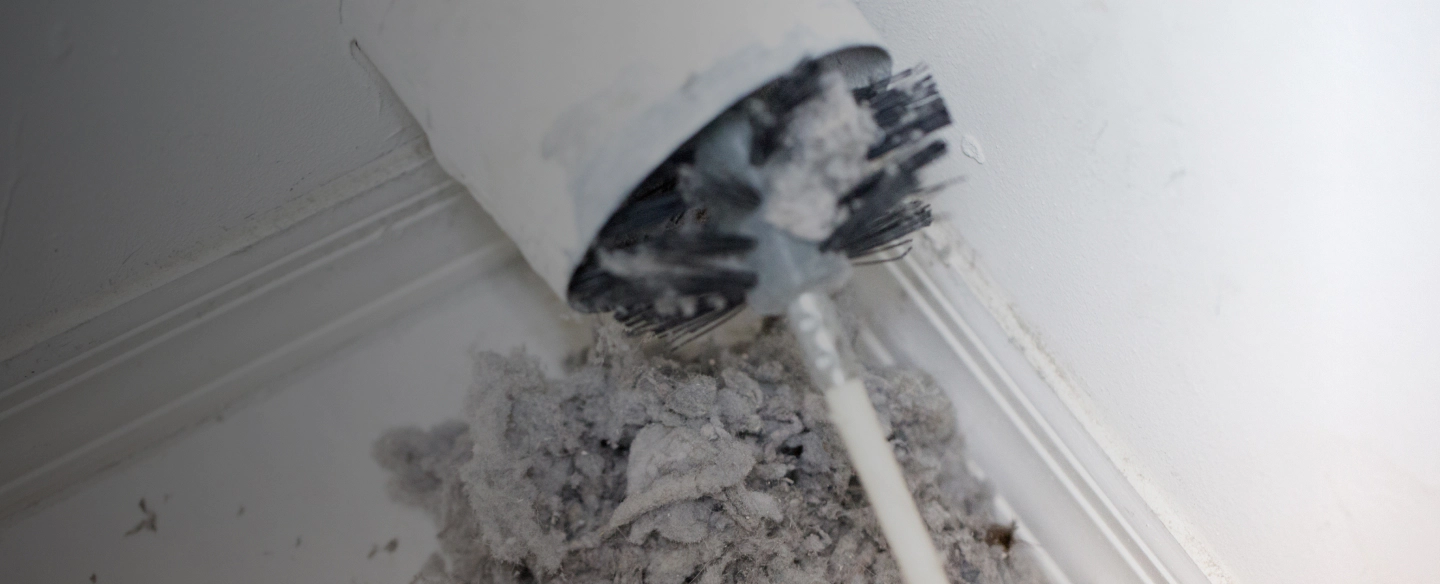 lint being removed from a dryer vent